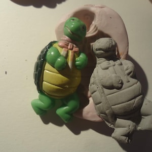 Puede incluir: Una taza de cerámica blanca con un asa negra y el texto "But First, Coffee" en negrita negra. La taza está sobre una superficie blanca. La taza mide 10 cm de alto.