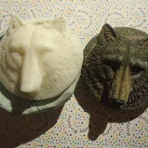 Puede incluir: Dos moldes de cabeza de lobo, uno blanco y otro marrón, sobre un fondo de confeti.