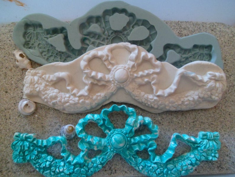 Pu&ograve; includere: Due stampi in silicone per realizzare decorazioni a nastro decorative. Lo stampo superiore &egrave; azzurro e lo stampo inferiore &egrave; turchese.