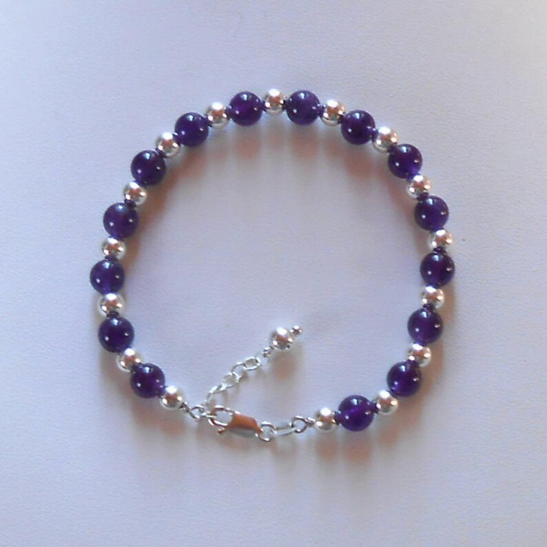 Puede incluir: Un brazalete de cuentas de amatista p&uacute;rpura y plata con un cierre de plata.