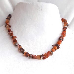 Short necklace with rhodonite and orange agate chip beads and gold clasp