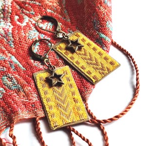 Gelbe Stoffcollage-Ohrringe auf bronzefarbener Metallplatte mit Stern-Charme