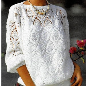 Peut inclure: Pull en crochet blanc avec un motif de dentelle délicat. Le pull a un col rond et des manches longues.