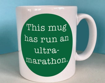 May include: White ceramic mug with a green circle that says "This mug has run an ultra-marathon."