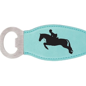 May include: A turquoise blue leather bottle opener with a metal bottle opener attached. The leather portion has a black silhouette of a person riding a horse jumping over a fence.