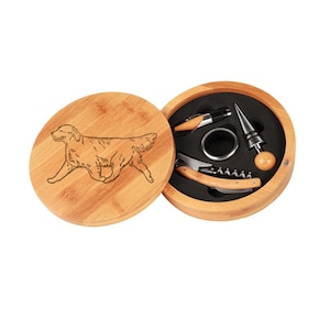 May include: A wooden box with a golden retriever engraved on the lid. The box contains a wine opener, a bottle stopper, and a foil cutter.
