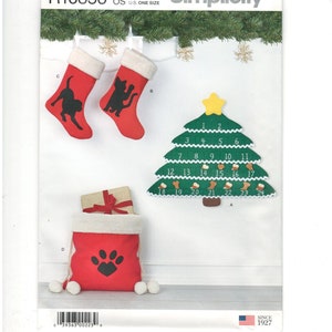 May include: Simplicity pattern for Christmas decorations. Includes red stockings with black cat silhouettes, a green felt Christmas tree advent calendar, and a red gift bag with a paw print.