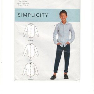 Pode incluir: Padrão de costura Simplicity R10439 para camisas. O padrão inclui opções clássicas, slim e relaxadas. A imagem mostra uma pessoa com uma camisa listrada e calças azul escuro. O padrão é para tamanhos 3-6.