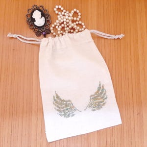 Pochon en coton beige ailes d'ange brodé avec un fil métallisé vert et or
