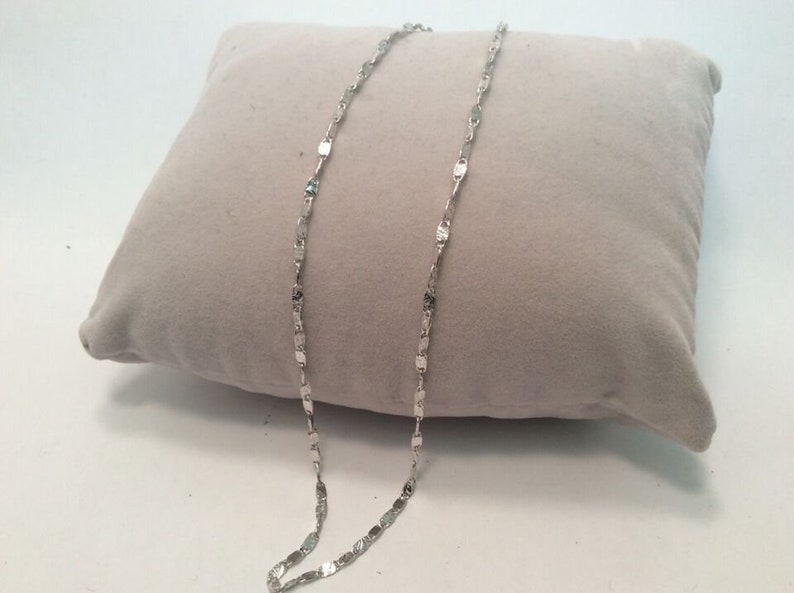 May include: A silver chain necklace with a delicate, textured, square-shaped link design.