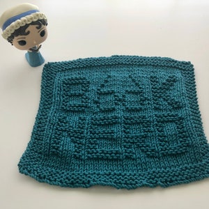 May include: A teal blue knitted dishcloth with a woven pattern.