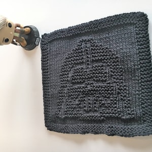 Könnte beinhalten: Ein dunkelgrauer, gestrickter Geschirrtuch mit einem erhabenen Design des Star Wars-Logos.
