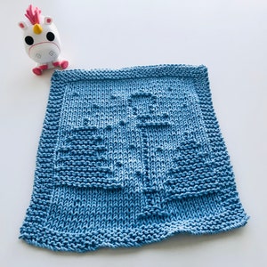 May include: A blue knitted dishcloth with a simple design. The dishcloth is made with a textured stitch and has a square shape.