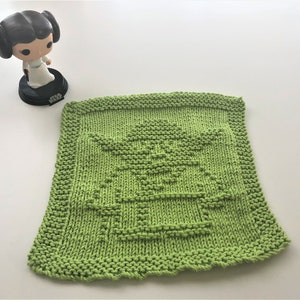 May include: Green knitted dishcloth with a Yoda design.