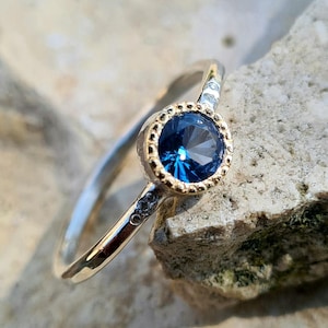 Ring aus 925er Silber und 18-karätigem Gold mit einem blauen Topas.