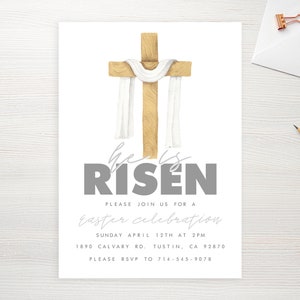 May include: A white card with a watercolor illustration of a wooden cross with a white cloth draped over it. The text "he is RISEN" is in gray letters. The card also includes the text "PLEASE JOIN US FOR A Easter celebration SUNDAY APRIL 12TH AT 2PM 1890 CALVARY RD. TUSTIN, CA 92870 PLEASE RSVP TO 714-545-9076".