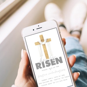 May include: A smartphone displaying a digital invitation for an Easter celebration. The invitation features a watercolor illustration of a wooden cross with a white cloth draped over it. The text reads "He is Risen" in gray lettering. The invitation includes the date, time, and location of the event, as well as an RSVP number.