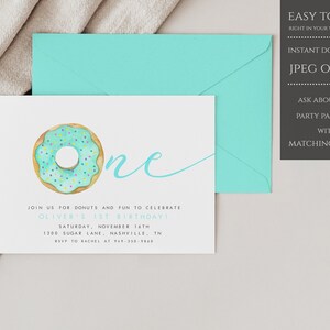 May include: A light blue and green donut with sprinkles on top. The donut is next to the word "one" written in a light blue cursive font. The text "Join us for donuts and fun to celebrate Oliver's 1st birthday!" is below the donut. The text "Saturday, November 16th" is below the first line of text. The text "1200 Sugar Lane, Nashville, TN" is below the second line of text. The text "RSVP to Rachel at 949-350-9860" is below the third line of text. The background of the invitation is white.