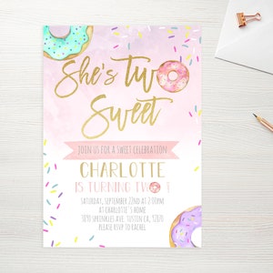 May include: Pink and white birthday invitation with gold lettering that says "She's Two Sweet". The invitation features a donut graphic and sprinkles. The text also includes the name Charlotte, the date, time, and location of the party, and an RSVP request.