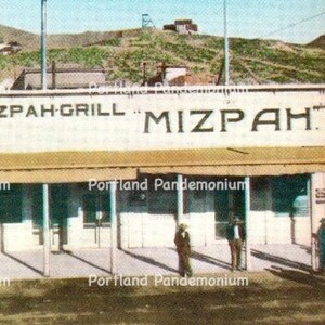Postal vintage a color de Mizpah Grill, Tonopah, Nevada: antes de la construcción del Hotel Mizpah. También muestra el antiguo banco, limpio y sin usar.
