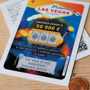 Peut inclure: Un ticket de jeu &agrave; gratter rectangulaire portant les inscriptions Fabulous LAS VEGAS, GAGNEZ JUSQU'&Agrave; 50 000 &euro; et TU VAS &Ecirc;TRE ARRI&Egrave;RE GRAND-M&Egrave;RE. La carte pr&eacute;sente un graphisme de machine &agrave; sous avec trois symboles de pommes sur un fond bleu, orange et noir.