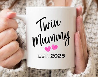 May include: White ceramic mug with black text that reads "Twin Mummy Est. 2025" and two pink hearts.