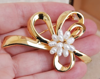 Broche vintage con lazo de cinta en tono dorado y perlas de agua dulce.