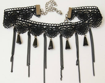 May include: Black lace choker necklace with dangling chains and black bead accents.