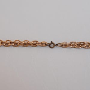 Puede incluir: Un collar de cadena de oro con cierre de broche.