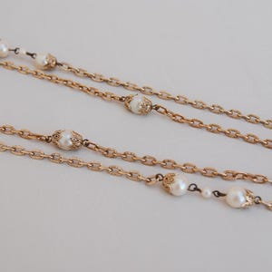 Puede incluir: Un collar de cadena de oro con m&uacute;ltiples hebras y detalles de perlas. Las perlas est&aacute;n engastadas en engastes de oro ornamentados.