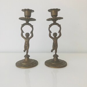 Pair of brass putti angel candlestick holders