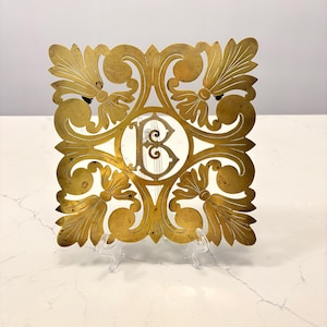 Antik fransk mässingsunderlägg med monogram och hjul