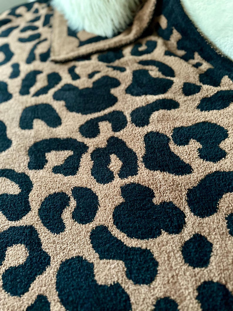 May include: A soft, plush throw blanket with a leopard print pattern in black and tan.