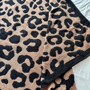 May include: A soft, plush throw blanket with a brown and black leopard print pattern.