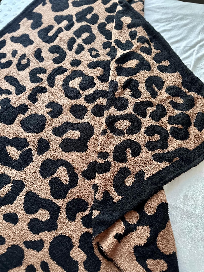 May include: A soft, plush throw blanket with a brown and black leopard print pattern.