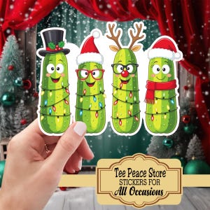 May include: Four Christmas-themed pickle stickers. Each pickle is decorated with a different festive accessory: a top hat, Santa hat, reindeer antlers, and a red scarf. The pickles are wrapped in string lights. The stickers are from Tee Peace Store.