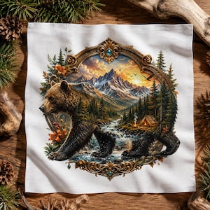 May include: A white square fabric cloth featuring a central ornate gold frame containing a detailed illustration of a brown bear walking near a mountain stream, a forest, a small tent, and a sunset sky with birds, surrounded by orange flowers.