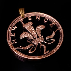 Può includere: Una moneta britannica da due pence di colore rame con un design ritagliato che presenta il drago gallese e le parole "TWO PENCE".
