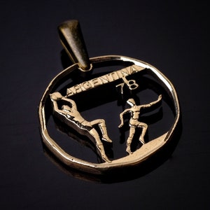 May include: Gold-toned pendant featuring two basketball players in silhouette, with the word "ARGENTINA" and the number "78" above them.