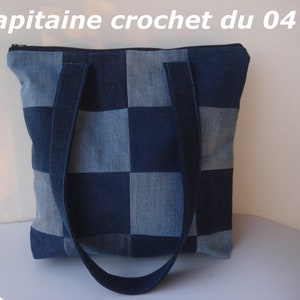 Peut inclure: Un sac cabas en jean bleu avec une fermeture éclair et deux longues poignées. Le sac est fait de carrés de jean patchwork.