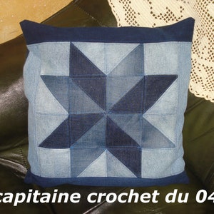 Peut inclure: Un coussin en jean bleu avec un motif de patchwork en forme d'étoile. Le coussin est sur un canapé en cuir marron. Le texte "capitaine crochet du 04" est visible en bas de l'image.