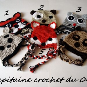 May include: Six crocheted hats with animal faces and ear flaps. The hats are in various colors, including red, brown, gray, and white. Each hat has a long crocheted string attached to the bottom. The hats are numbered 1 through 6.