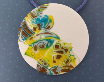 round white yellow green and blue pendant, matte and shiny abstract pattern, blue waxed cord, very light