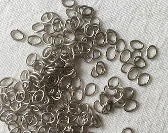 Un conjunto de 50 anillos ovalados en metal plateado oscuro. Anillos de 5mm para acabado de joyería DIY. Accesorio, anillo de unión