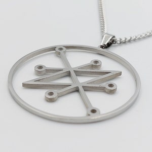 Peut inclure: Un collier en argent avec un pendentif circulaire orné d'un motif géométrique. Le pendentif est en métal et a une forme circulaire avec un motif en forme d'étoile à l'intérieur.