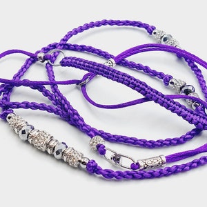 May include: Purple braided cord with silver beads and a silver clasp. The cord is braided with a decorative knot at the end.