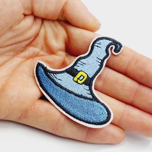 May include: A blue witch hat with a yellow buckle embroidered patch.