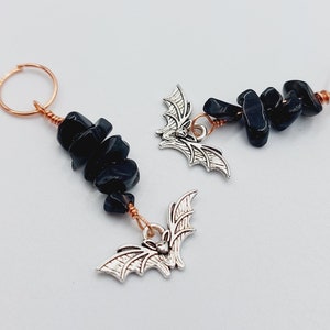 May include: Two black onyx stone and silver bat charm earrings with copper wire and hoops.