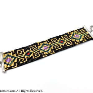 May include: A black beaded bracelet with a gold and multi-colored geometric pattern. The bracelet has a silver clasp and a silver chain.