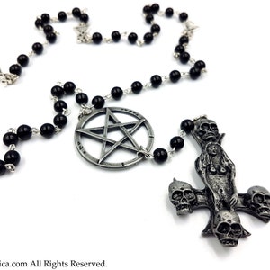 Op de afbeelding: Een zwarte kralenrozenkrans met een pentagram hanger en een zilveren kruis met schedels. Het kruis toont een vrouwelijke figuur met haar armen gespreid.